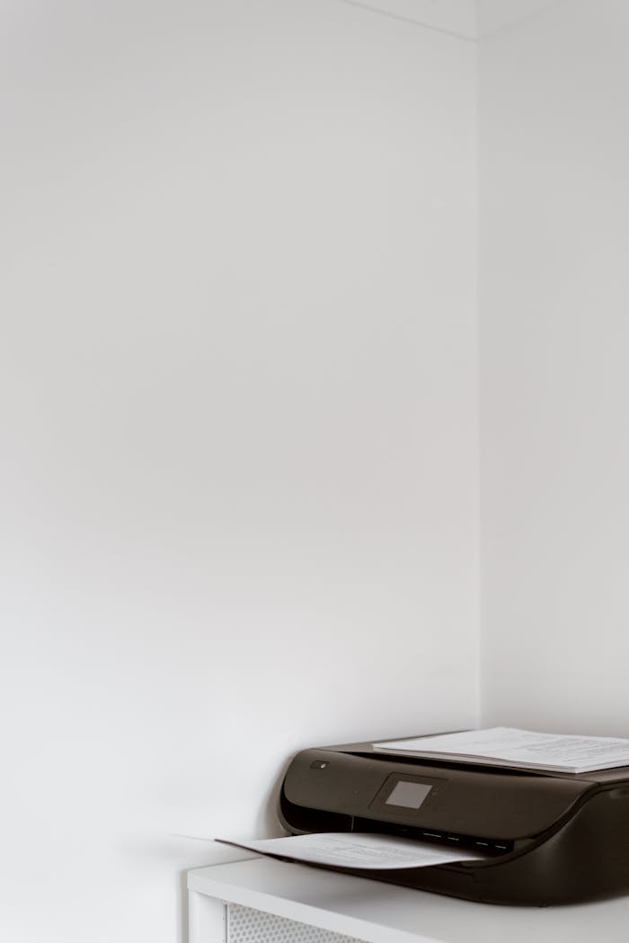 services-03 A sleek black printer in a modern office corner on a white cabinet with ample copy space.